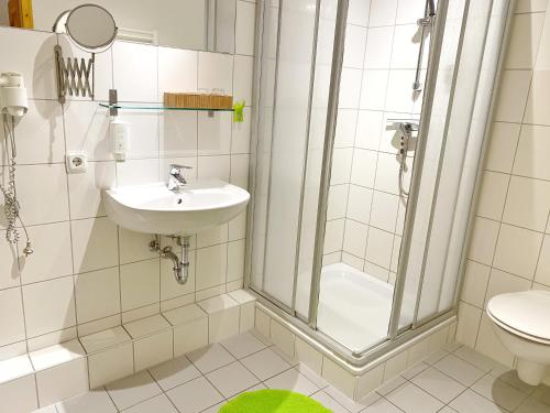ein Bad mit einer Dusche, einem Waschbecken und einem WC in der Unterkunft Sassnitz - Seaside Appartements Seaside Appartements, "Green" in Sassnitz