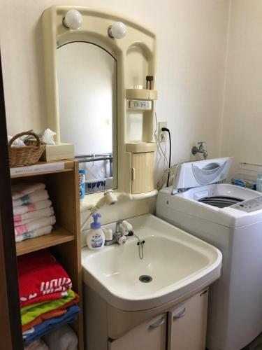 bagno con lavandino, specchio e lavatrice di 民泊　二見のおうち a Hutami