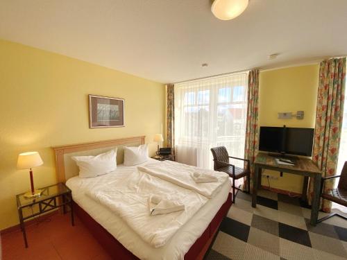 een hotelkamer met een bed en een televisie bij Appartements am Rondell Neddesitz, Appartement 308 in Neddesitz