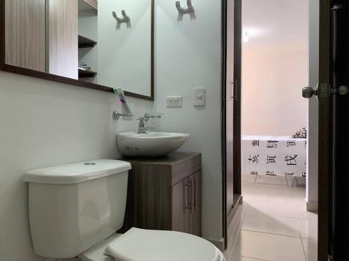 y baño con aseo blanco y lavamanos. en Full furnished apartment in Pereira, en Pereira
