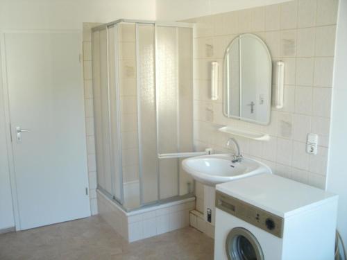 a bathroom with a sink and a washing machine at Gästehaus Harz -Monteurzimmervermietung- in Vienenburg