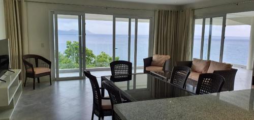 a living room with a couch and chairs and the ocean at Noor Villa - Luxury 3 Bed, 2 Bath Apartment with Stunning Panoramic Sea View, Private Beach in Pinamihagan