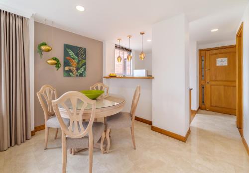 a kitchen and dining room with a table and chairs at Alcazar de Oviedo by EE Hoteles in Medellín