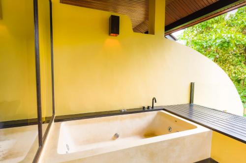 a bath tub in a bathroom with a window at Chantaramas Beach Resort Koh Phangan in Baan Khai