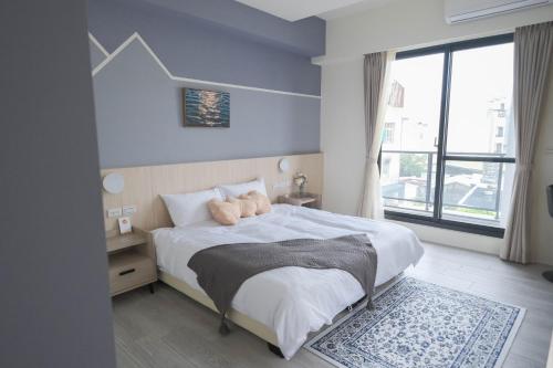 1 dormitorio con cama y ventana grande en Zhou Ping, en Anping