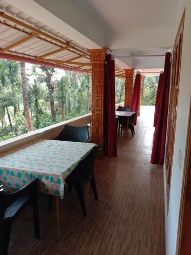 a room with a table and chairs and a window at Shivalaya Homestay in Madikeri