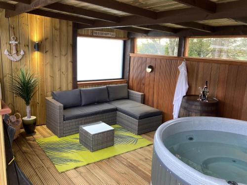 a room with a tub and a couch in a room at The Steading in Rogart