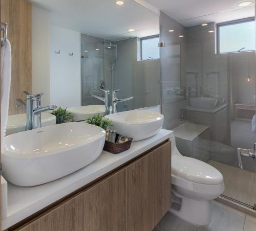 a bathroom with two sinks and a toilet at Alcazar de Oviedo by EE Hoteles in Medellín