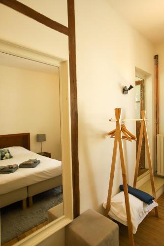a mirror in a room with a bed and a tripod at La Basse Cour in Tanlay