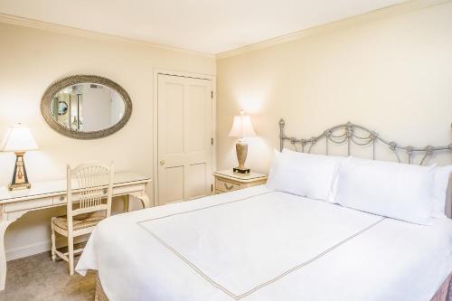 a white bedroom with a bed and a desk at Silverado Resort and Spa 221 in Napa