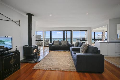 a living room with two couches and a stove at Il Mare The Ocean in Skenes Creek