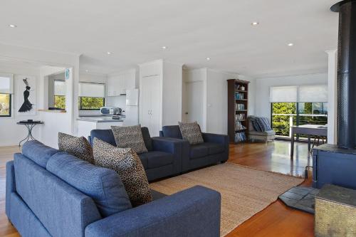 a living room with two blue couches and a fireplace at Il Mare The Ocean in Skenes Creek