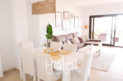 マニルバにあるHola! apartments at Coto Realの白いダイニングルーム(白いテーブル、白い椅子付)