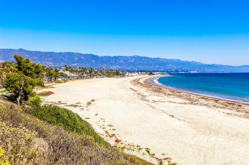 a sandy beach with palm trees and the ocean at Sailaway Cabin A in Ventura