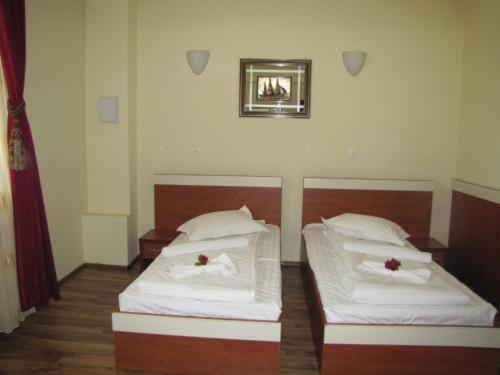 a room with two beds with white sheets at Bistro 29 in Ploieşti