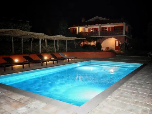 a swimming pool at night with a house in the background at Apartma Villa Cedole Chabby Chick in Piran