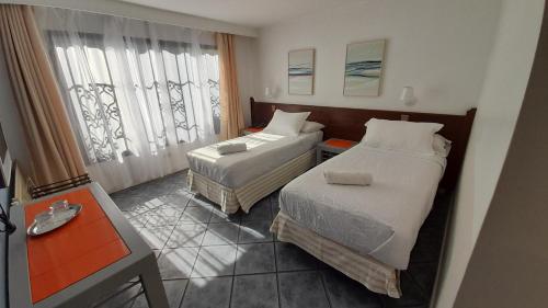 een hotelkamer met twee bedden en een raam bij HOTEL BORDEPLAZA - ex Monterilla in Viña del Mar