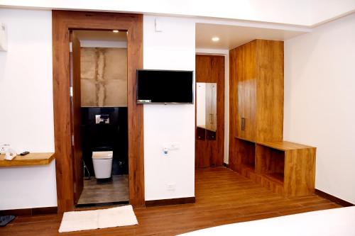 a room with a television and a room with a bathroom at MY Heritage Resort - Best Resort in Kannauj in Kannauj