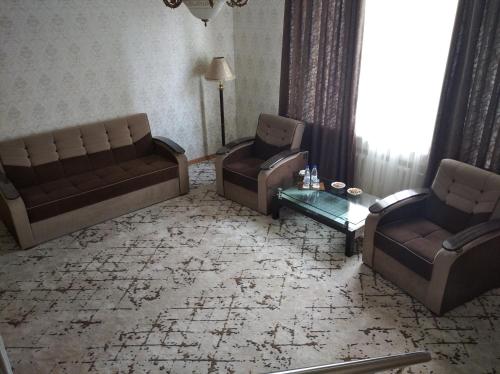 a living room with two couches and a table at Asia Hotel Fergana in Fergana