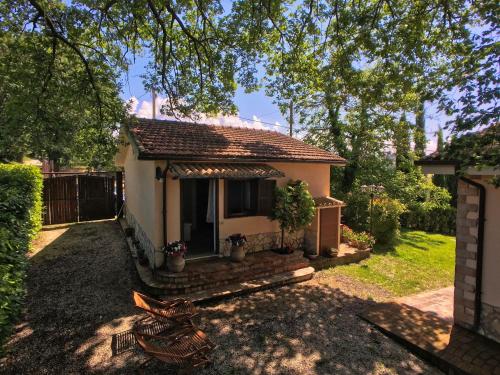 una piccola casa in un giardino con un albero di Tranquil holiday home in Selci with swimming pool a Selci