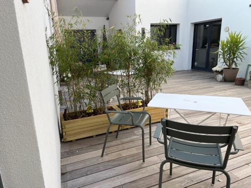 a table and chairs on a patio with plants at Le patio d'Oscar in Failly