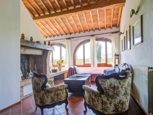 ein Wohnzimmer mit 2 Stühlen und einem Kamin in der Unterkunft Belvilla by OYO Orchidea Primo Piano in Peccioli