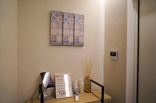 a desk with a picture on the wall and a shelf with medicines at Sinori205 in Hakodate