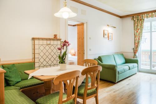 a living room with a table and a couch at NaturResidence Dolomitenhof in Siusi