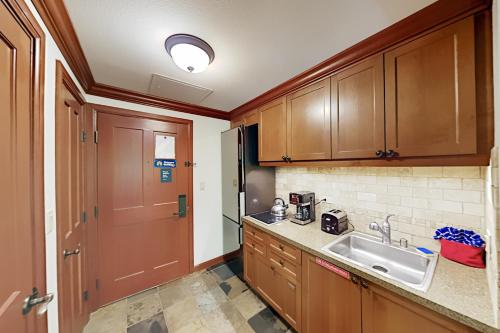 a kitchen with wooden cabinets and a sink at Resort at Squaw Creek's 126 & 128 in Olympic Valley