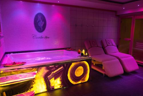 a purple room with a pool table and chairs at Villa Caribe Resort & Spa in Spigno Saturnia