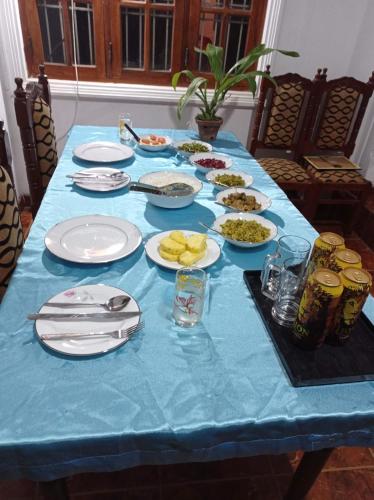 a blue table with plates of food on it at Sudu Neluma Home Stay in Polonnaruwa