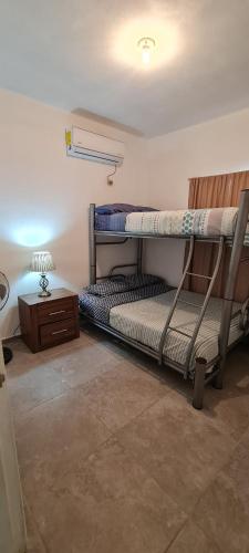 una habitación con dos literas y una mesa en GATED AND VERY SECURED WHITE HOUSE 6 MINS FROM THE BEACH, en Puerto Peñasco