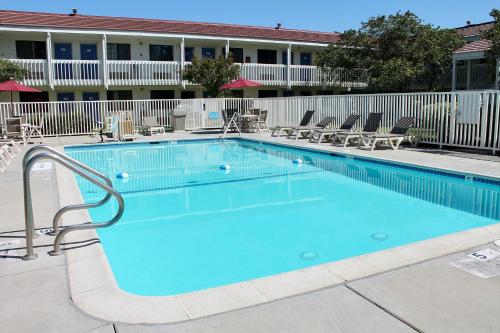 a large swimming pool with chairs and a building at Motel 6-San Luis Obispo, CA - South in San Luis Obispo