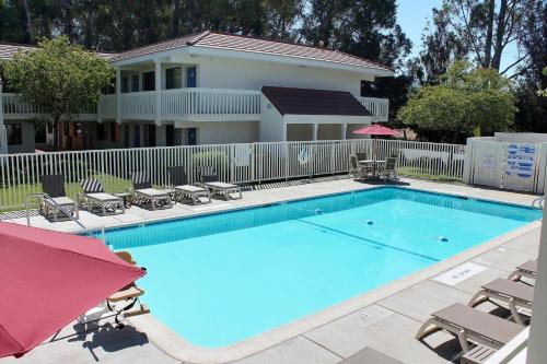 a large swimming pool with chairs and a house at Motel 6-San Luis Obispo, CA - South in San Luis Obispo