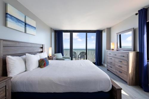 a bedroom with a bed and a view of the ocean at Hosteeva 17th Floor Palms Resort Penthouse Oceanfront w Balcony in Myrtle Beach