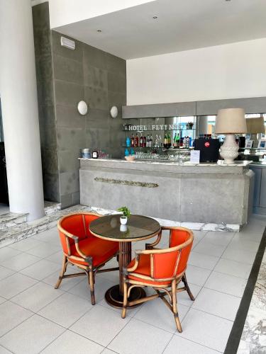 a table and two chairs and a counter with a bar at HOTEL FLYING in Pesaro