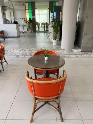 a table and two orange chairs in a building at HOTEL FLYING in Pesaro