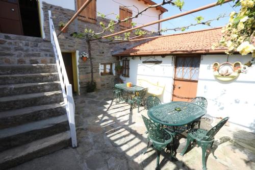 un patio con mesa, sillas y escaleras en Casa Adalcina (casa d'avó), en Mirandela
