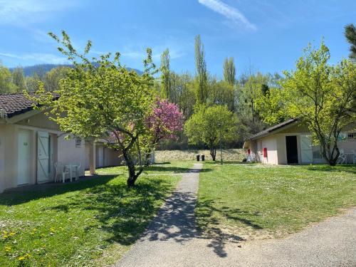 a path leading to a house with trees in the yard at Le Pré du Lac in Saint-Jorioz