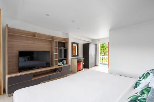 a bedroom with a large bed with a flat screen tv at 4U Resort Samui in Lamai