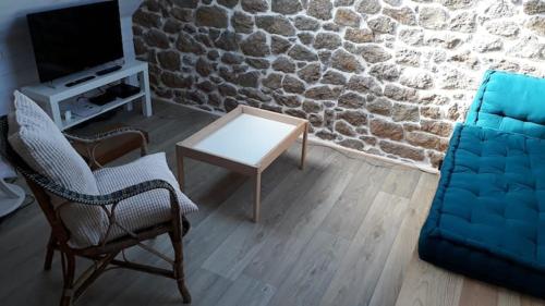uma sala de estar com um sofá e uma mesa em La p'tite maison de la plage em Fermanville