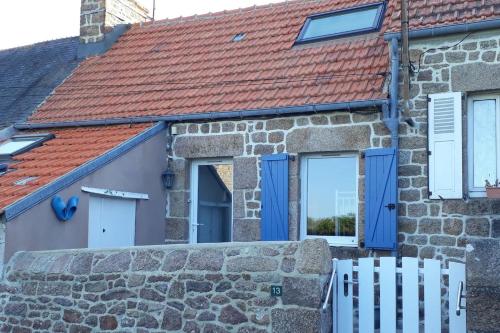 Ce cottage dispose de fenêtres bleues et d'un toit rouge. dans l'établissement La p'tite maison de la plage, à Fermanville