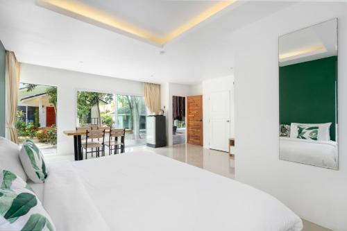 a bedroom with a white bed and a dining room at 4U Resort Samui in Lamai