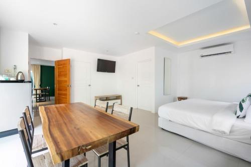 a room with a dining room table and a bed at 4U Resort Samui in Lamai