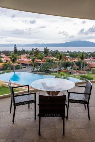 a table and chairs on a balcony with a view of a pool at El Dorado Ajijic by Restavio in Ajijic