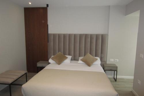 a bedroom with a large white bed with two pillows at Freddy's Hotel in Tirana