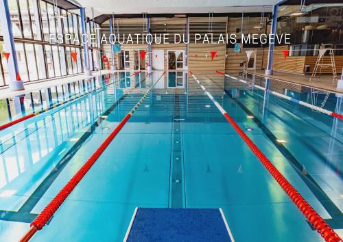 a large swimming pool in a large building at Novotel Megève Mont-Blanc in Megève