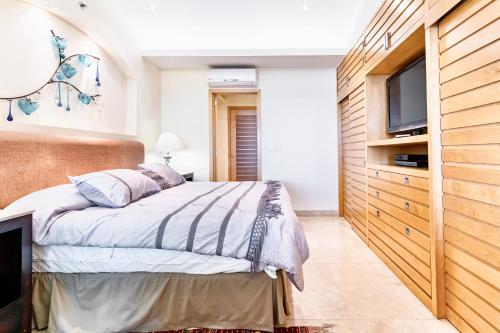 a bedroom with a bed and a flat screen tv at El Dorado Ajijic by Restavio in Ajijic