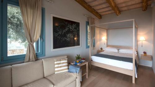 um quarto com uma cama de dossel e um sofá em Villa Adelphia, luxury villa in Alonnisos em Isómata