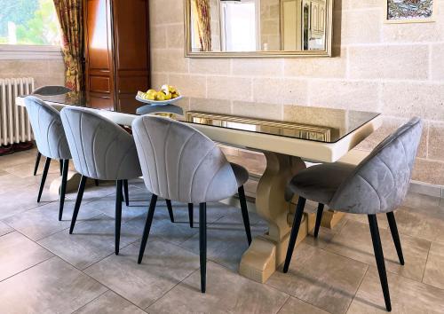 een eettafel met stoelen en een spiegel bij Villa Marguerite in Coutras